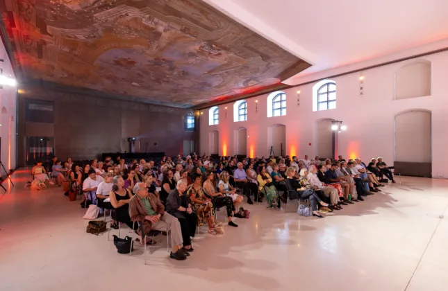 Blick über Publikum im Saal, Deckenfresko gut sichtbar