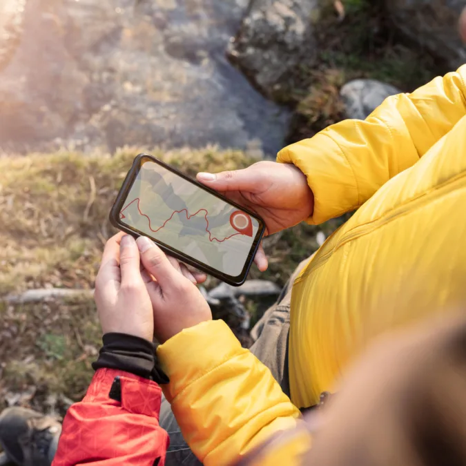 Menschen mit GPS-Navigator-App, Waldwandern, Paar auf dem Berg bei Sonnenuntergang
