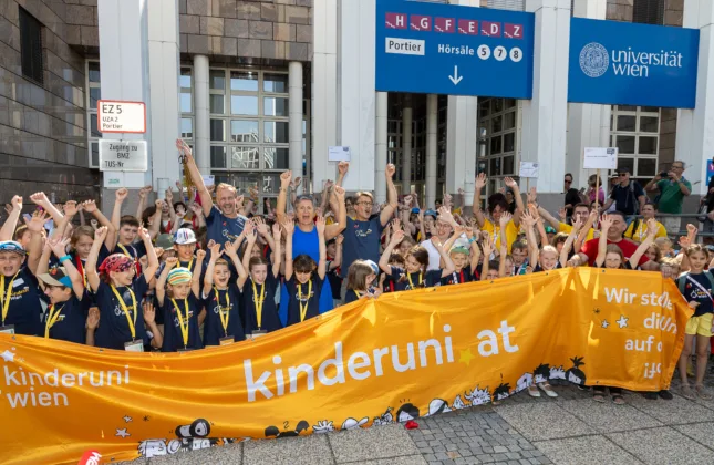 Kinder vor der Universität Wien mit Banner kinderuni.at